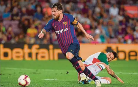  ??  ?? PENYERANG sensai Barcelona, Lionel Messi melepasi asakan pemain Alaves.