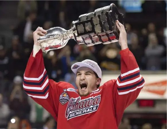  ?? JACQUES BOISSINOT/THE CANADIAN PRESS ?? Ecstatic Generals captain Josh Brown shows off the Memorial Cup after Oshawa won junior hockey’s championsh­ip with a 2-1 OT victory over the Rockets Sunday night in Quebec City.