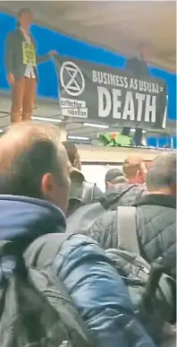  ??  ?? REGRET: Extinction Rebellion protesters on the roof of an Undergroun­d train surrounded by angry commuters at Canning Street Station