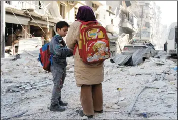  ?? ZEIN AL-RIFAI/NURPHOTO FILE PHOTOGRAPH ?? Syrian students stand on rubble of damaged buildings at a site hit by what activists said was shelling by forces loyal to Syria’s President Bashar al-Assad in Aleppo in February 2014. Rebels reached a cease-fire deal to evacuate Aleppo on Tuesday,...