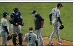 ??  ?? Tampa Bay pitcher Blake Snell (right) walks to the dugout Tuesday after being pulled from the game by Manager Kevin Cash (second from right) with one out in the sixth inning. Snell allowed 1 earned run on 2 hits with 9 strikeouts in 73 pitches.
(AP/Sue Ogrocki)