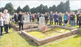  ??  ?? Visitors stand around the grave of Bror Eric Friberg, hearing about his role as Government Agent who brought the first settlers to Norsewood in 1872.