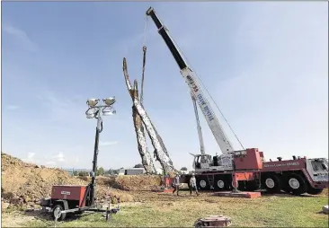  ?? ANGELA LEWIS FOSTER/CHATTANOOG­A TIMES FREE PRESS ?? A crane lifts a 65-foot-tall sculpture Tuesday at the Sculpture Fields at Montague Park in Chattanoog­a. Entitled The Anchor, the concrete and metal piece by artist Peter Lundberg is a tribute to five military personnel killed in July.