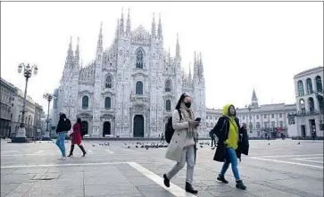  ?? Luca Bruno Associated Press ?? A WOMAN in a mask passes the Milan Duomo. Italy has seen rapidly rising numbers of coronaviru­s cases.