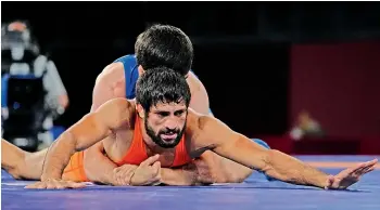  ??  ?? India’s Ravi Dahiya competes with Zavur Uguev of Russian Olympic Committee in the men’s freestyle 57kg final wrestling match in Tokyo on Thursday. Ravi secured a silver medal as Uguev won 7-4.