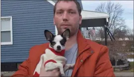  ?? MITCH HOTTS — MEDIANEWS GROUP ?? Dino Rasera holds Marble the Chihuahua after the dog was left alone at the remains of a Mount Clemens apartment fire for two weeks. The pint-sized miracle was finally spotted over the weekend and reunited with her owner.