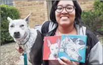  ?? Associated Press ?? Danielle Moore with her dog, Kana, in March, holding paintings of the Australian cattle dog in Dallas. In the dog- eat- dog world of online shopping, Chewy has an unusual plan to fend off Amazon: turning pets into works of art. The online pet shop surprises customers with oil paintings of their furry friends, a move the company says wins them customers for life.