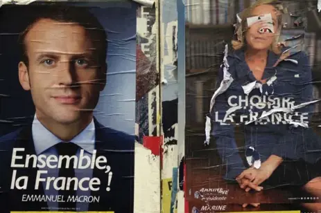  ?? CLAUDE PARIS/THE ASSOCIATED PRESS ?? Electoral poster of centrist candidate Emmanuel Macron and a defaced poster of far-right candidate Marine Le Pen, Wednesday in Marseille, France.