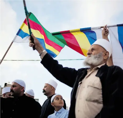  ?? ARIEL SCHALIT/THE ASSOCIATED PRESS ?? Members of Israel’s Druze minority wave flags during a march in the Druze village of Yarka, Israel, earlier this month.