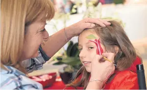  ??  ?? Freya Bruce, 10, having her face painted by a volunteer at the Union Square mall