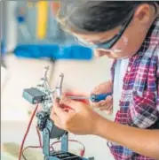  ?? GETTY IMAGES ?? ▪ A student fixing a robot arm in a workshop.