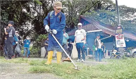  ??  ?? DR Daud (tengah) memotong rumput ketika Program Gotong-Royong Perdana di Bongawan, semalam.
