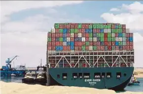  ?? EPA PIC ?? Egyptian tugboats trying to ‘dislodge’ the ‘Ever Given’ container ship stranded in the Suez Canal yesterday.