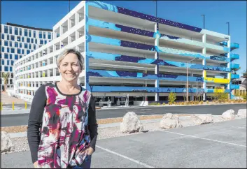  ?? Downtown Summerlin ?? Bonnie Kelso, local artist and Summerlin resident, shows off her design, which now graces three sides of the 1700 Pavilion parking garage.