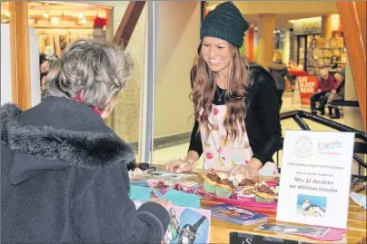  ?? EMILY ACORN/THE GUARDIAN ?? Emma Turner’s grandmothe­r visits her cupcake booth at the Confederat­ion Court Mall on National Cupcake Day Monday. The national promotion raises funds for animal shelters across Canada through cupcakes baked and sold by local supporters.