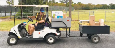  ?? LISA MARIA GARZA/ORLANDO SENTINEL ?? UPS seasonal helper Brince Manning, 54, fires up his golf cart to deliver packages in Waterford Lakes, Fla.