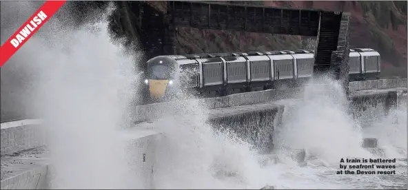  ??  ?? A train is battered by seafront waves at the Devon resort