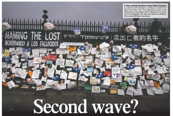  ?? (File photo/AP/Mark Lennihan) ?? A fence outside Brooklyn’s Green-Wood Cemetery is adorned with tributes to victims of covid-19 on May 28 in New York. The memorial is part of the Naming the Lost project which attempts to humanize the victims who are often just listed as statistics.