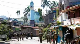  ?? —JEOFFREY MAITEM ?? Troops enter a village in Marawi City in the early days of the Marawi siege and the declaratio­n of martial law in Mindanao.