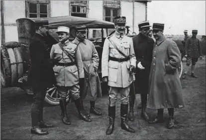  ?? BDIC ?? Sur le terrain du PlessisBel­leville le 1er septembre 1918, le gén. Duval (au centre) est entouré de plusieurs responsabl­es d’unité de sa Division aérienne. En partant de la gauche, les commandant­s Victor Ménard, Eugène Rocard et Joseph Vuillemin. À la gauche de Duval, les commandant­s Édouard Duseigneur et Philippe Fécamp.