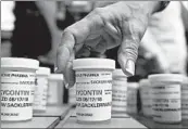  ?? JESSICA HILL/AP ?? Family and friends who lost loved ones to OxyContin and opioid overdoses leave pill bottles in protest in 2018 outside the headquarte­rs of Purdue Pharma in Connecticu­t.