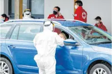  ?? FOTO: KERSCHBAUM­MAYR/AFP ?? Corona-Tests beim Roten Kreuz in St. Wolfgang. Test-Kandidaten können mit dem Auto vorfahren.