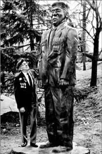  ?? JIM WILKES/TORONTO STAR ?? Bill Bettridge, 84, a veteran of D-Day, admires the oak likeness of himself in Brampton’s Gage Park, carved as a tribute to veterans.