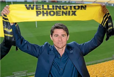  ??  ?? Darije Kalezic holds up a Wellington Phoenix scarf at Westpac Stadium after his announceme­nt as the coach.