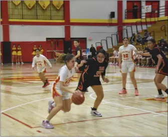  ?? JEANS PINEDA/Taos News ?? Katie Alire drives against Tatiana Flores on Tuesday (Feb. 21).