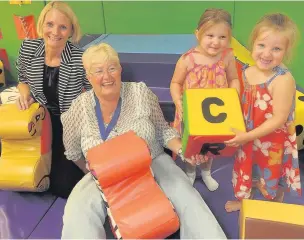  ?? ALISTAIR WILSON
AN143989 ?? Mayor of Rushmoor, Cllr Diane Bedford, centre, tries out the new play area with Wellington Centre manager Jemma Fern, Juliet and Keavie-Rae.