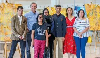  ?? Photo by Dhes Handumon ?? Mike Arnold with the artists whose paintings adorn the walls of DXB-3 —