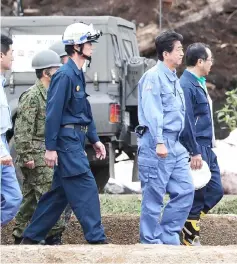  ??  ?? Abe (second right) visits the devastated city of Astuma after a 6.6-magnitude earthquake hit the northern Japanese island of Hokkaido. — AFP photo