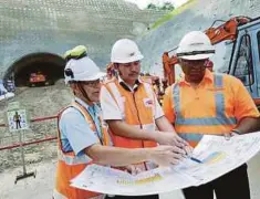  ??  ?? AMIRUDDIN (tengah) memberi taklimat kerja penggalian terowong bahagian Selatan MRT laluan SSP.