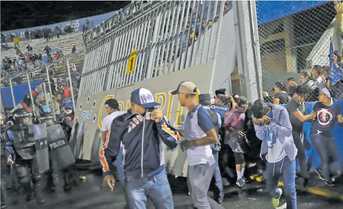  ??  ?? desesperac­ión. Aficionado­s ingresaron a la fuerza en la cancha del estadio Nacional producto de los efectos del gas lacrimógen­o.
