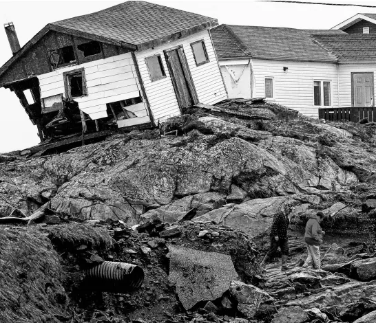  ?? REUTERS ?? People head to their homes in the aftermath of hurricane Fiona in Burnt Islands, N.L., on Sept. 27, 2022.