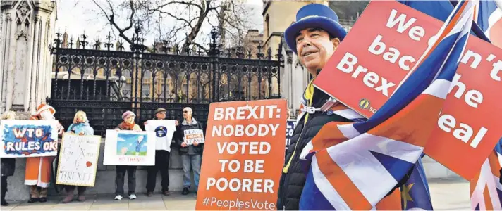  ??  ?? Manifestan­tes a favor y en contra del Brexit protestan frente al Parlamento en Londres.