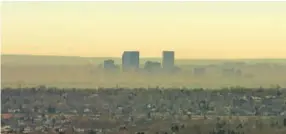  ?? RJ Sangosti, Denver Post file ?? A brown cloud surrounds Denver in this file photo. Oil and gas regulators have proposed rules that aim to improve air quality in the state.