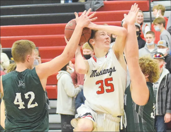 ?? RICK PECK/SPECIAL TO MCDONALD COUNTY PRESS ?? McDonald County’s Eli McClain takes the ball to the basket against Mount Vernon’s Tristian Jones (left) and Dominic Dawson during the Mustangs’ 76-60 loss on Feb. 19 at MCHS.