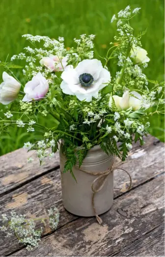  ??  ?? The bold papery petals of anemones are paired with an effervesce­nt spray of cow parsley in a pottery vase.