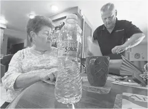  ?? MARK HOFFMAN/ USA TODAY NETWORK ?? Mary Lou and Arlin Karnopp look through test results of their private well. They are pressing regulators to address drinking water contaminat­ion in Kewaunee County, Wis.