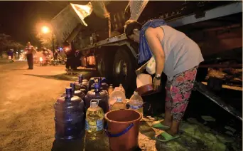  ?? (SUN.STAR FOTO/ALLAN CUIZON) ?? FREE OIL, ANYONE? A woman takes advantage of the free edible oil on offer after a wing van transporti­ng it to Leyte fell on its side in Liloan, Cebu last Wednesday morning.