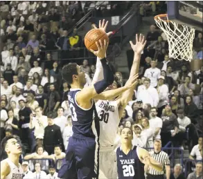  ?? Steve Musco / Yale Athletics ?? Yale’s Alex Copeland, left, shoots over Harvard’s Danilo Djuricic on Saturday.