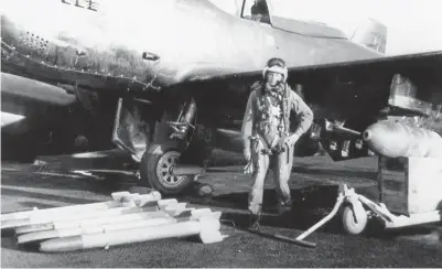  ?? (Photo by Carl Fraser) ?? Lt. “Skeeter” Hudson posed by his F-82 at Itazuke AB, Japan as his ship is being loaded with bombs, rockets, and .50 caliber rounds. This was before they were to fly a close air support mission over the North in November 1950.