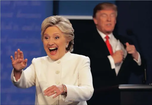  ?? PICTURE: AP ?? Democratic presidenti­al nominee Hillary Clinton waves to the audience as Republican presidenti­al nominee Donald Trump puts his notes away after the third presidenti­al debate at UNLV in Las Vegas.