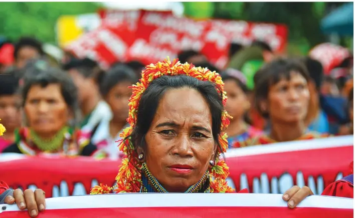  ?? CHRISTIAN MARK LIM ?? FRONT LINER. Despite the rain yesterday afternoon, some 1,000 protesters from different parts of Mindanao march towards the Department of Agricultur­e office on Bangoy St., Davao City where they will camp to demand for the release of the El Niño...