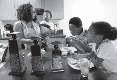  ?? Tribune News Service ?? Cherish Coates prepares a meal for her three children in Phoenix, Ariz., where she now lives. She gave birth to her son Allen as a frightened teenager 13 years ago and the boy’s father brought him to the hospital in a shoe box. She is now married and...