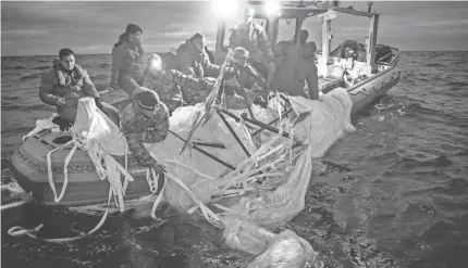  ?? OFFICER 1ST CLASS TYLER THOMPSON/U.S. NAVY VIA GETTY IMAGES ?? U.S. Navy and Coast Guard personnel recover pieces of the downed Chinese balloon on Sunday, the day after it was downed by a fighter aircraft. The Navy has now shifted to an all-underwater search to retrieve the remaining debris.