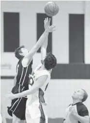  ?? DON HEALY/Leader-Post ?? The Regina College Luther Lions’ Jon Halvorson, left, and the Bishop Mahoney Saints’ Colin Fraser reach for the ball during Hoopla 2014 at F.W. Johnson Collegiate in Regina on
Thursday.