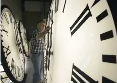  ?? — Reuters ?? Scott Gow adjusts a tower clock on test at the Electric Time Company in Medfield, Massachuse­tts. Daylight saving time began in the United States from 2 am on March 8.