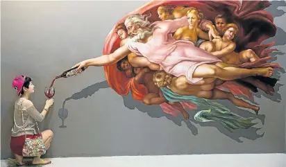  ?? Picture: GETTY IMAGES ?? A Chinese tourist poses with an irreverent version of Michelange­lo’s ‘The Creation of Adam’ at Art in Paradise, an interactiv­e art museum in Chiang Mai, Thailand. Due to the number of media clips of Chinese tourists behaving badly at the museum on Thai...